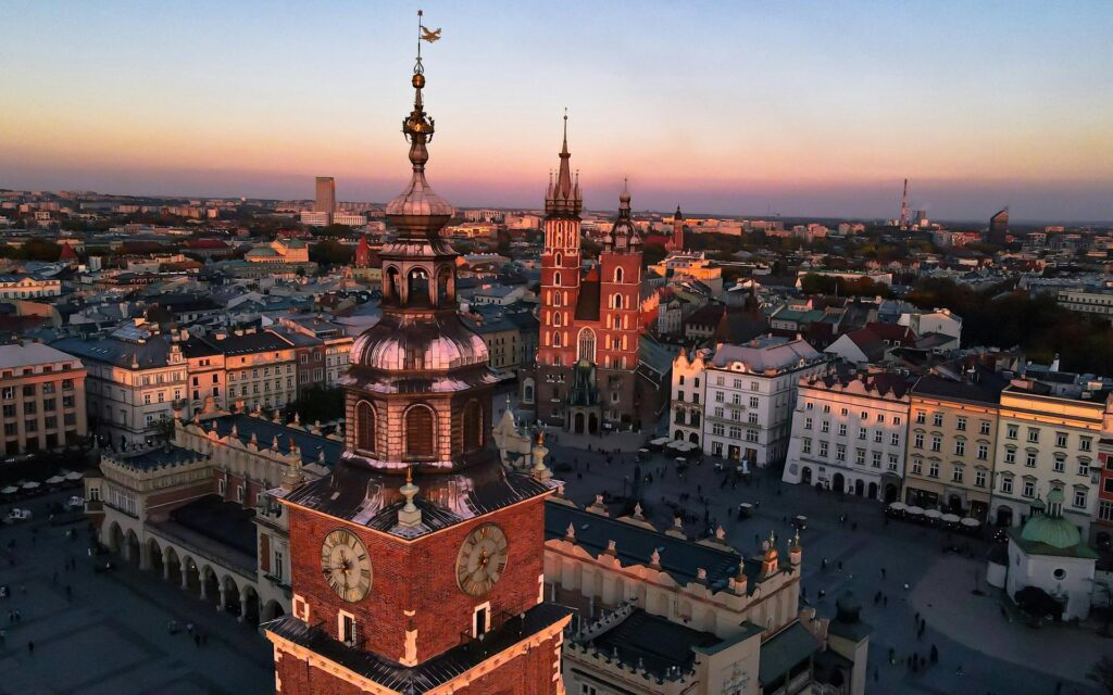 Rynek Główny w Krakowie o zachodzie słońca, wieża ratuszowa i Kościół Mariacki