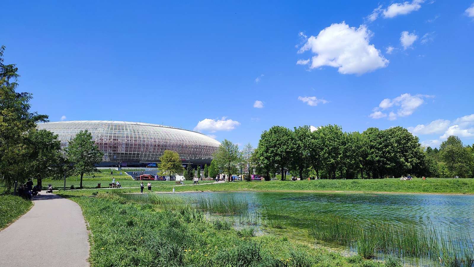 TAURON Arena Krakow and the pond in Lotników Polskich Park on a sunny day